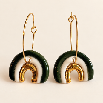 Green and white porcelain rainbow hoop earring worn on a model's ear