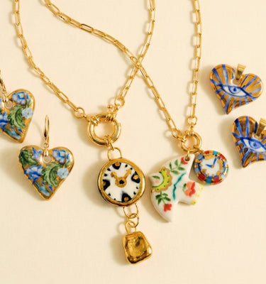 Gold necklace with heart-shaped charms on a beige background