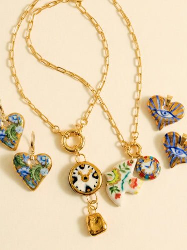 Gold necklace with heart-shaped charms on a beige background