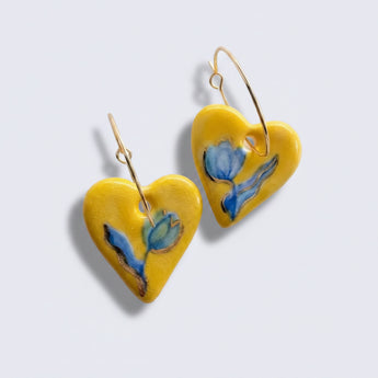 Heart-shaped earrings with a floral design on a yellow background