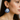 Celestial Gaze Porcelain Earrings in cobalt blue with 22k gold accents depicted on a model's ear, showcasing unique statement earrings that feature expressive moon faces.