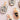 Oval-shaped ceramic pendants with hand-painted black ink illustrations of insects, celestial motifs, and a central heart with an eye, accented with metallic gold detailing