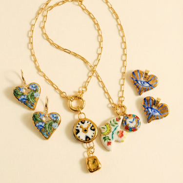 Gold necklace with heart-shaped charms on a beige background
