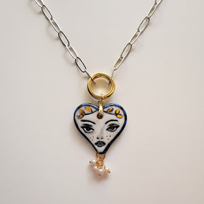 Hand-painted porcelain muse heart pendant necklace, close up of face motif and gold leaf crown