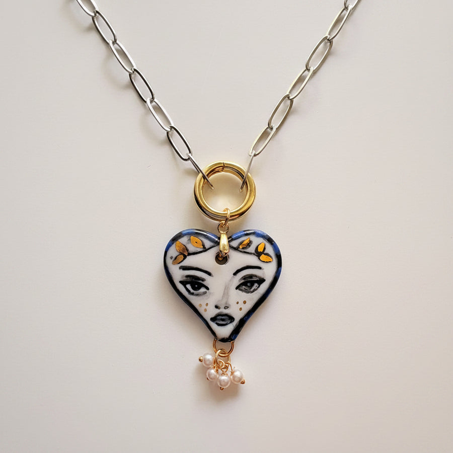 Hand-painted porcelain muse heart pendant necklace, close up of face motif and gold leaf crown