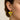 Yellow heart-shaped earring with floral design worn by a person against a neutral background