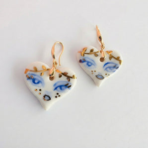 BitaJewells hand-painted white porcelain heart earrings with cobalt blue eyes and 22K gold accents. Hypoallergenic hooks.