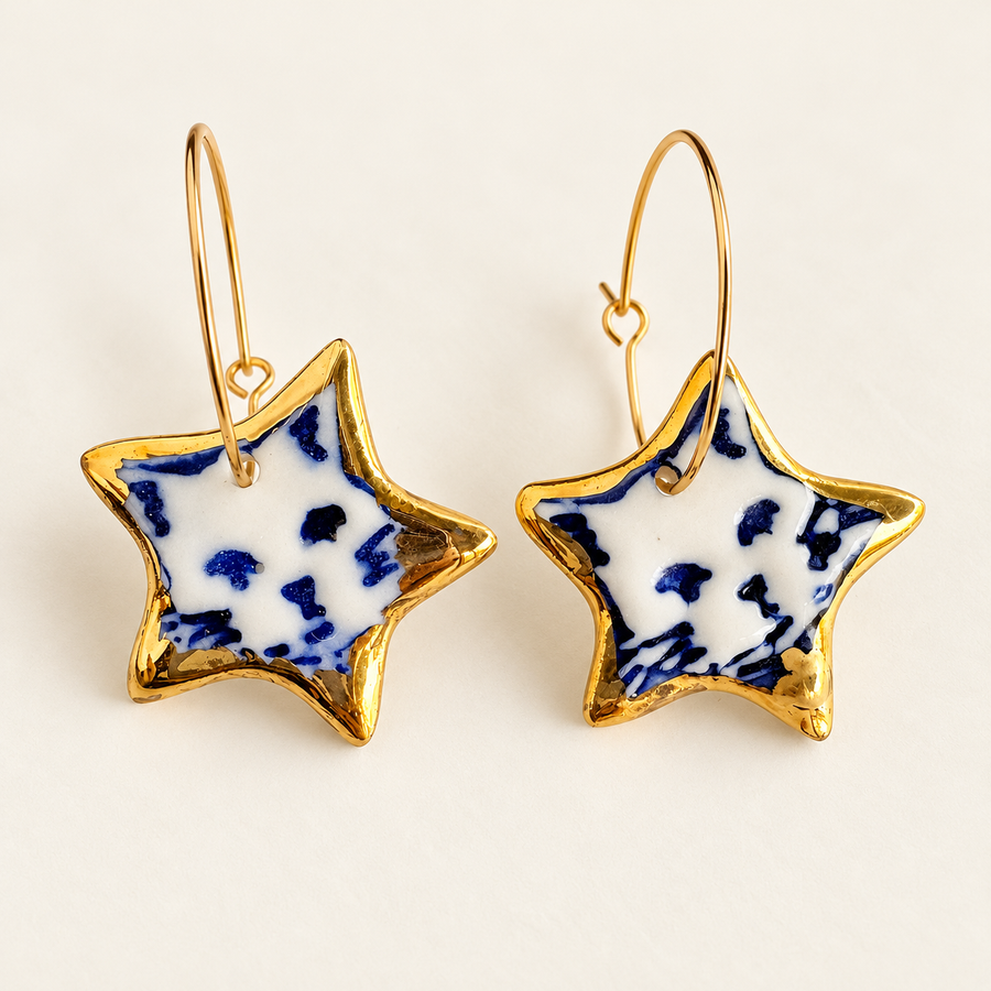 Pair of white porcelain star hoop earrings with hand-painted blue cat faces and gold lustre borders.