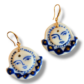 Beautiful hand-painted porcelain earrings by BitaJewells, featuring a cobalt blue moon face design, perfect for everyday wear. These artisan jewelry pieces serve as ideal gifts for her or a girlfriend, showcasing exquisite craftsmanship with a mix of gold accents. Ideal as a valentine gift, these unique white earrings add charm to any outfit. They're a stunning choice in handmade ceramic jewelry.