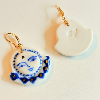 Close-up view of the Midnight Moonface hand-painted porcelain earrings by BitaJewells, highlighting intricate cobalt blue detailing and gold accents. These lightweight handmade ceramic earrings are perfect for anyone who appreciates artisan jewelry, making them a wonderful gift for her or a valentine gift. Their unique design ensures they stand out as a stylish accessory for everyday wear.