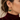 Forest green porcelain hoop earring with gold details worn on an ear